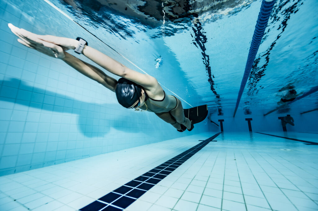 A freediver practicing in a swimming pool